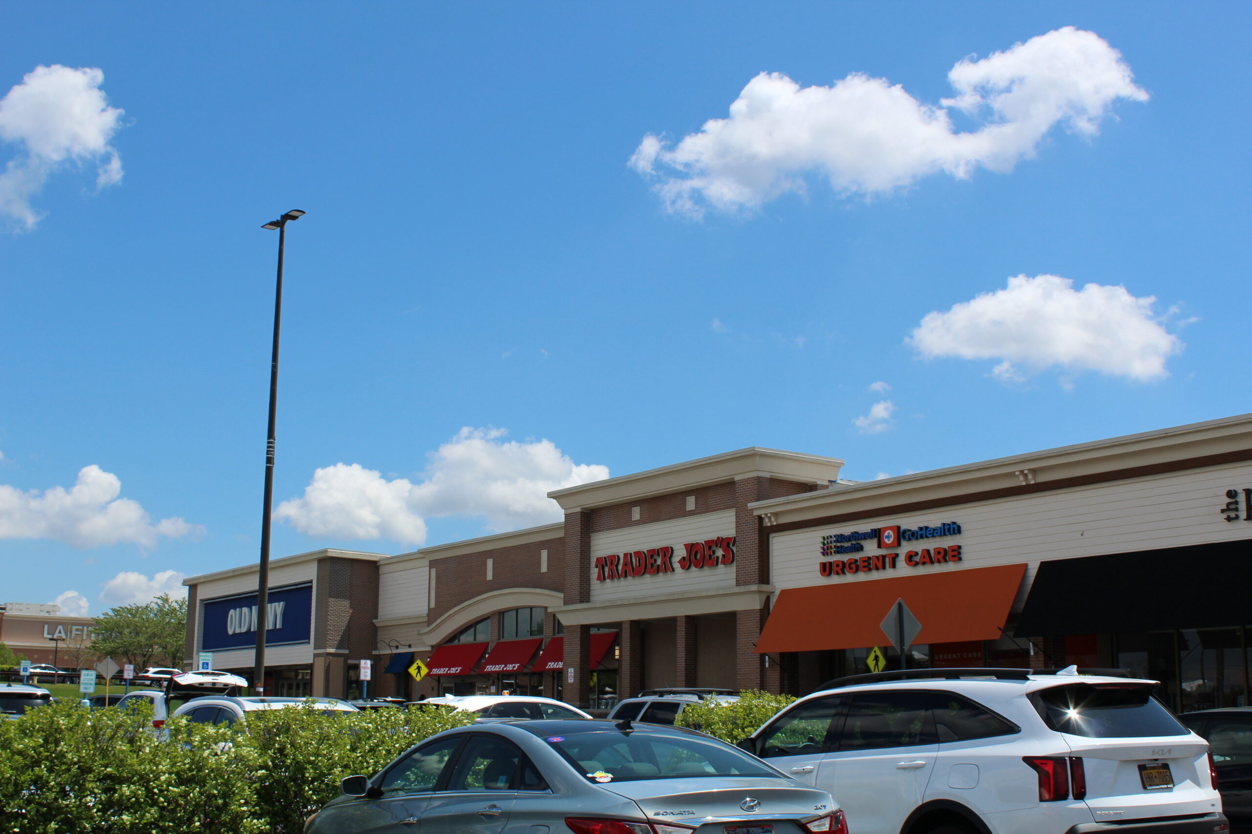 Trader Joe's store front in plaza next to Old Navy and an Urgent Care clinic